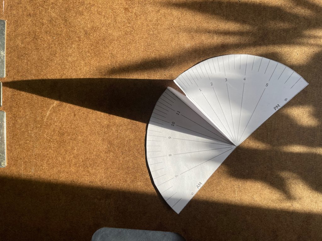 My paper sundial around 9:30am, about an hour before the second image. The light was more direct, so the gnomon's shadow was sharper.
